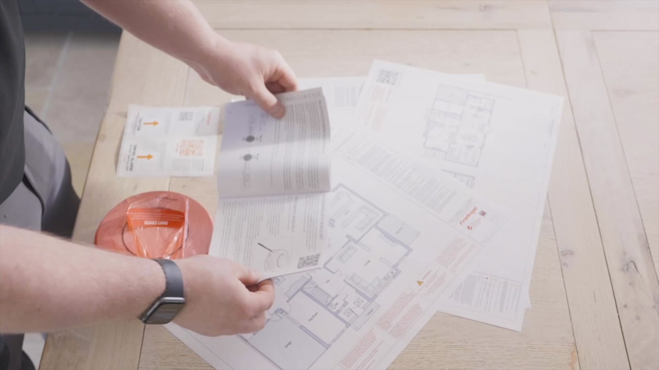 A FireAngel specialist reviewing floor plans and a detection schedule
